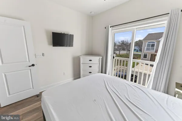 a bedroom with a bed and a flat tv screen on the dresser