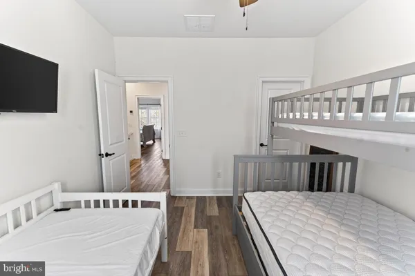 a bedroom with a bed and a flat tv screen on dresser