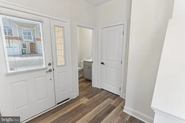 a view of a hallway with wooden floor and closet