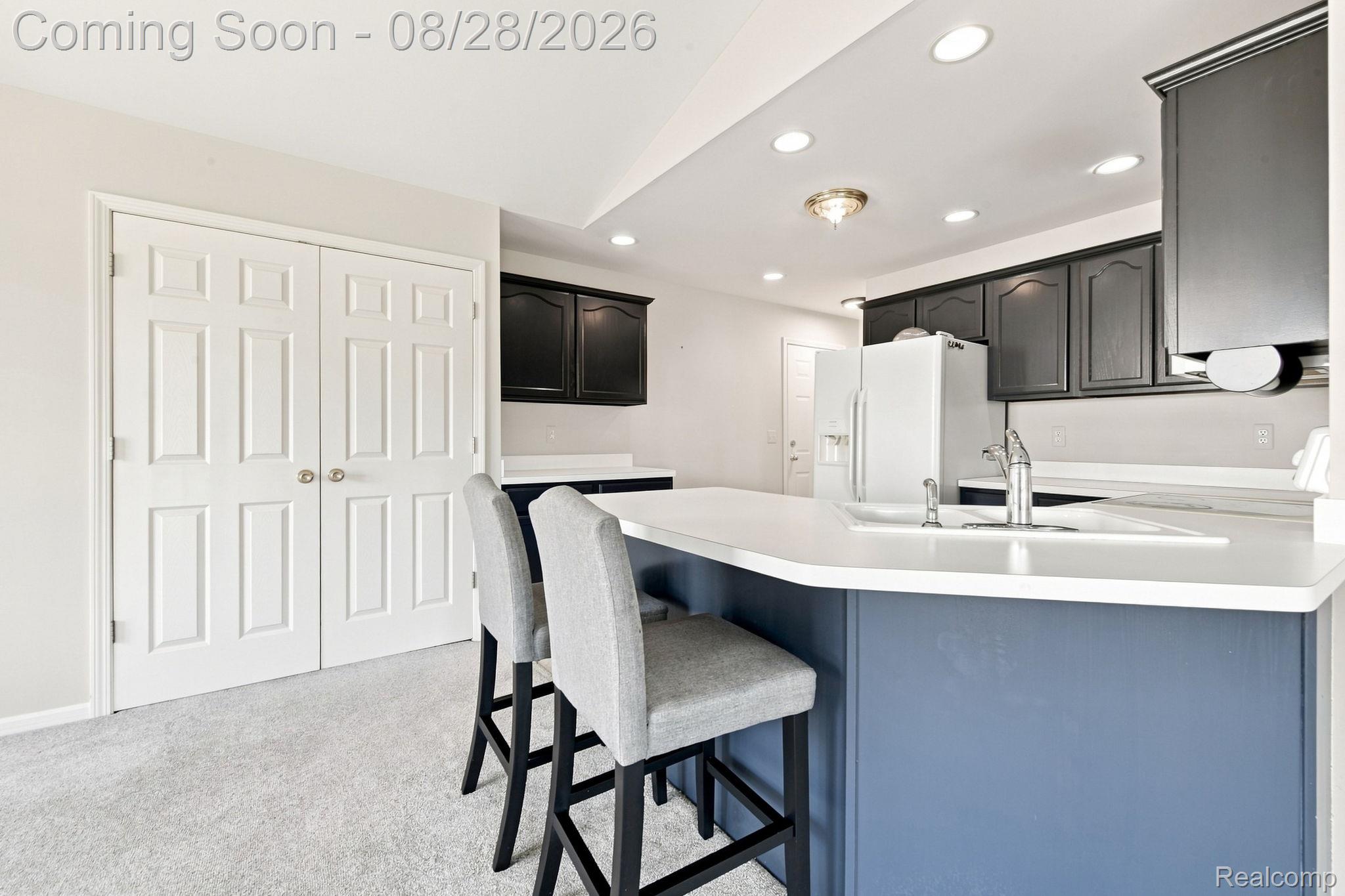 493 Harvard Drive Romeo, MI 48065 - Photo 10 of 36 Kitchen featuring a peninsula with a white countertop and an integrated sink, dark cabinetry, recessed lighting, and light gray wall paint