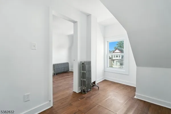 an empty room with wooden floor and a window