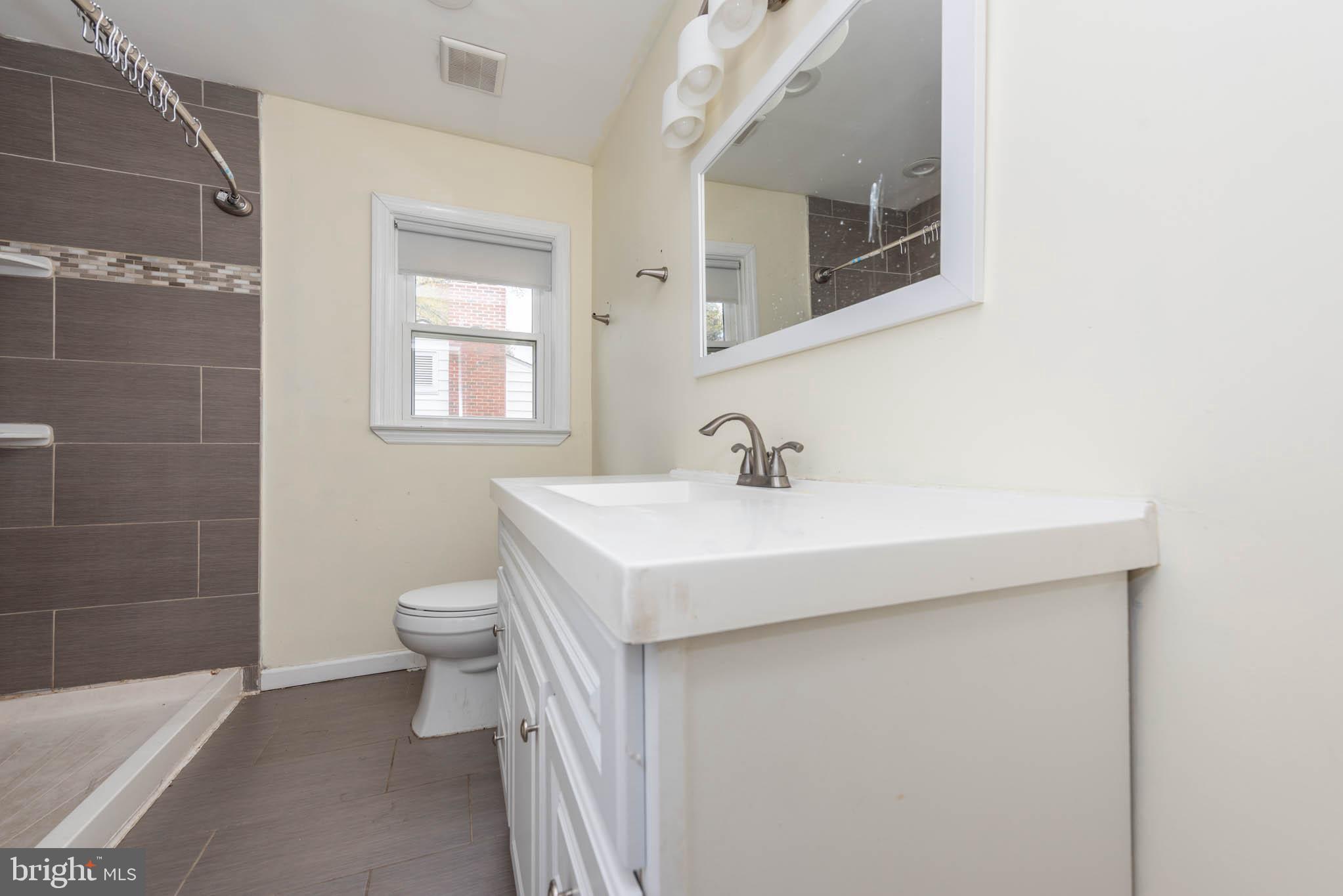 6702 Queens Ferry Road Baltimore, MD 21239 - Photo 13 of 40 a bathroom with a sink a toilet and shower