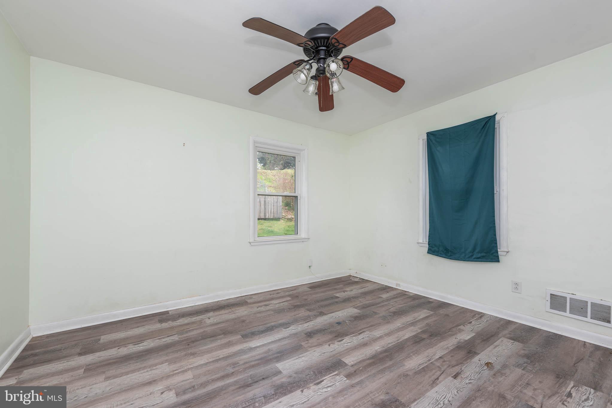 6702 Queens Ferry Road Baltimore, MD 21239 - Photo 15 of 40 an empty room with a window and a ceiling fan