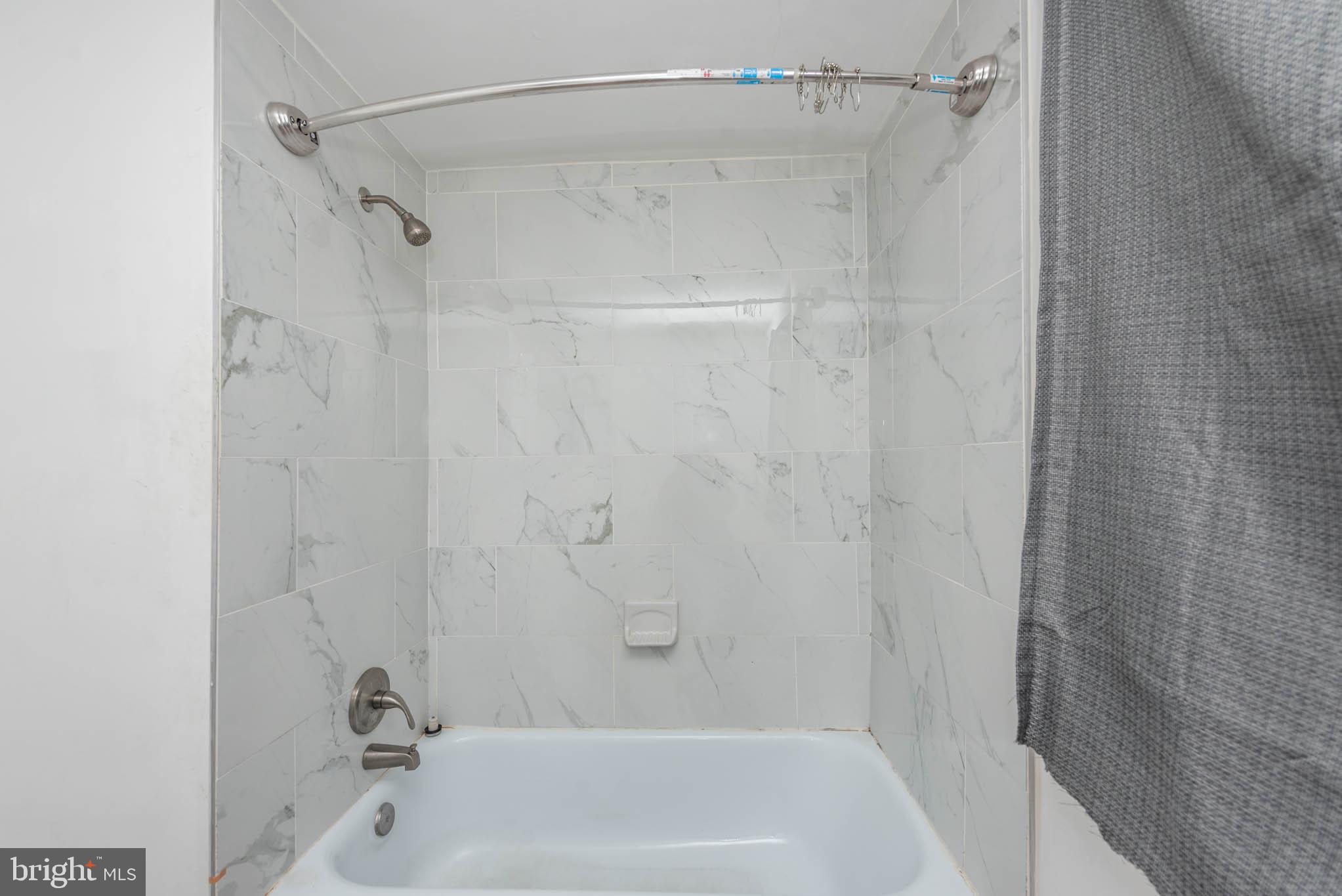 6702 Queens Ferry Road Baltimore, MD 21239 - Photo 20 of 40 a bathroom with a shower and a bath tub