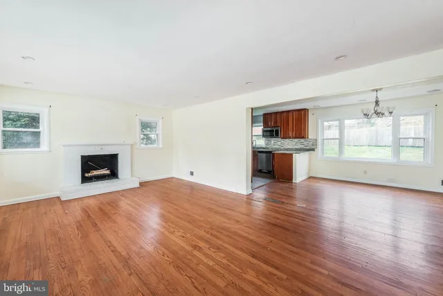 a view of empty room with wooden floor and fireplace