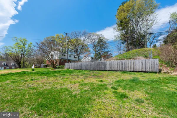 a view of a yard with a fence and trees