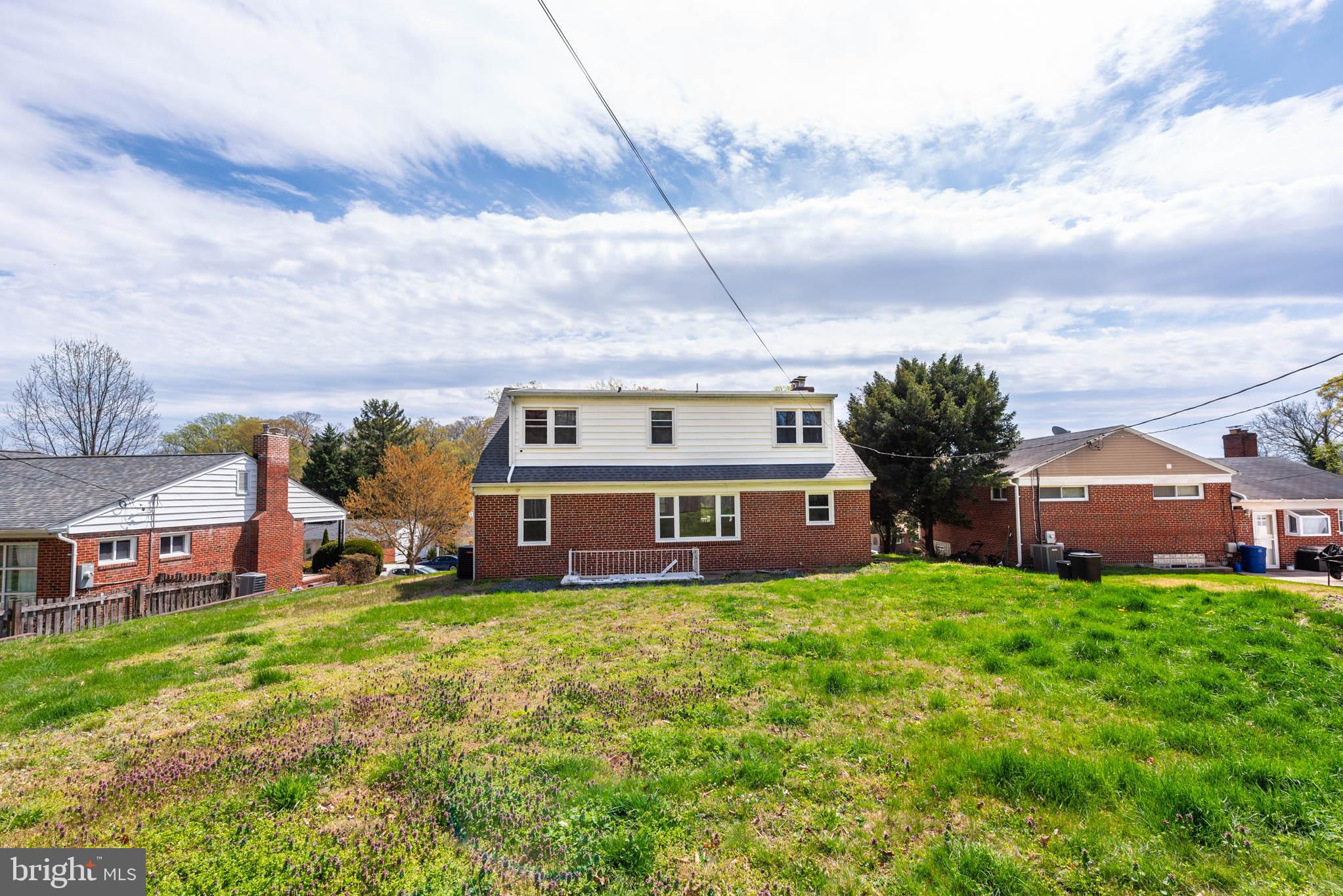 6702 Queens Ferry Road Baltimore, MD 21239 - Photo 35 of 40 front view of a house with a big yard and large trees