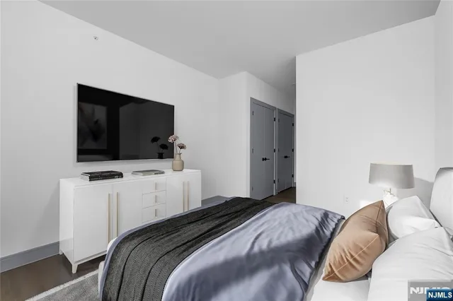 a bedroom with a bed and a flat screen tv