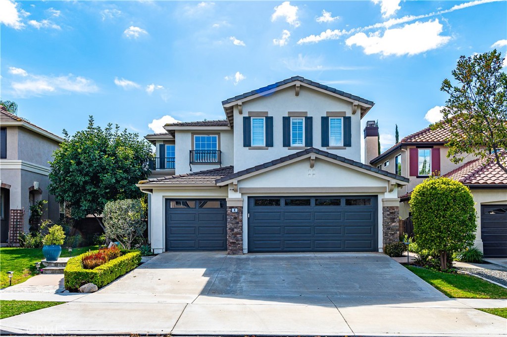 4 Whispering Pine Irvine, CA 92620 - Photo 2 of 12 a front view of a house with a yard and garage