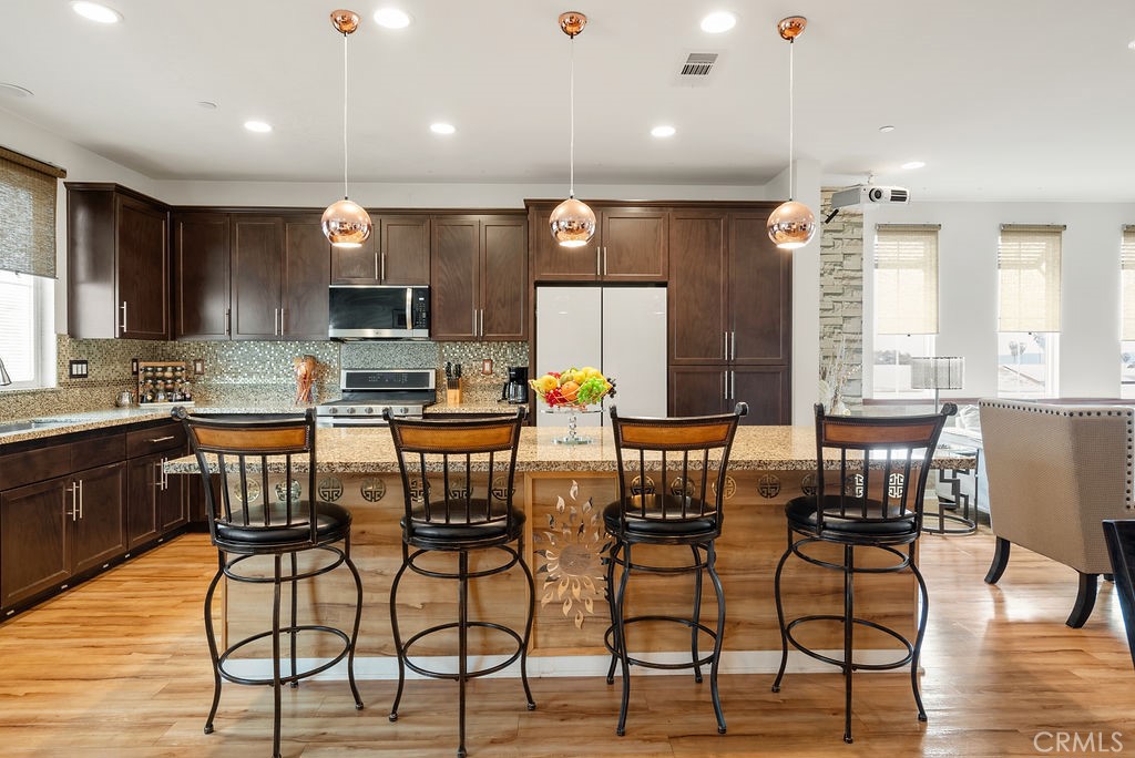 2705 Meyer Lane Pomona, CA 91767 - Photo 24 of 63 a kitchen with stainless steel appliances kitchen island granite countertop a stove a sink a dining table and chairs