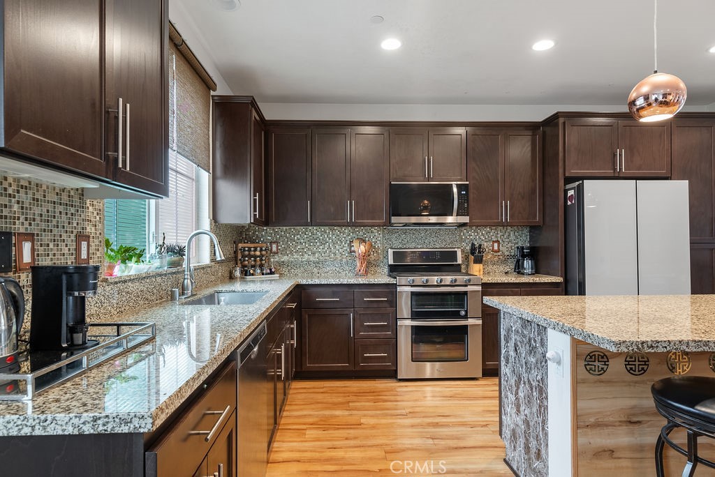 2705 Meyer Lane Pomona, CA 91767 - Photo 26 of 63 a kitchen with kitchen island granite countertop a stove sink and refrigerator