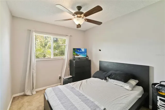 a bedroom with a bed and a ceiling fan