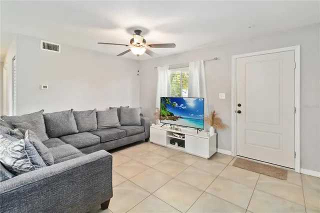 a living room with furniture a chandelier and a window