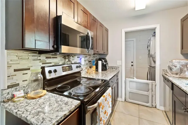 a kitchen with stainless steel appliances granite countertop a stove top oven a sink and a granite counter tops