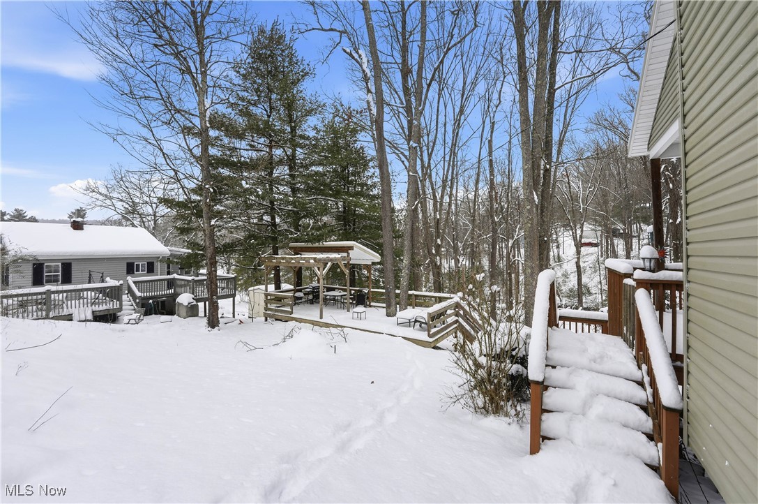 4254 Doral Road Southwest Carrollton, OH 44615 - Photo 37 of 46 Snowy yard with a wooden deck