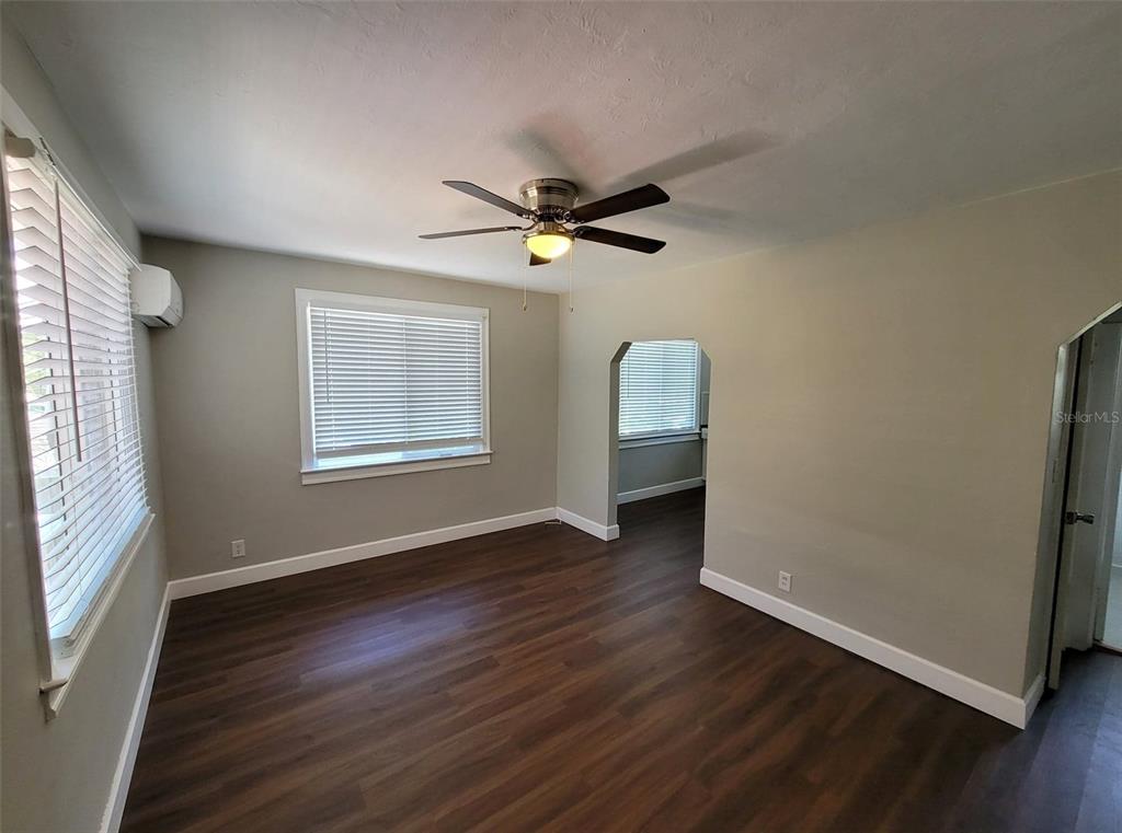 3301 West Woodlawn Avenue Tampa, FL 33607 - Photo 22 of 39 an empty room with wooden floor chandelier fan and windows
