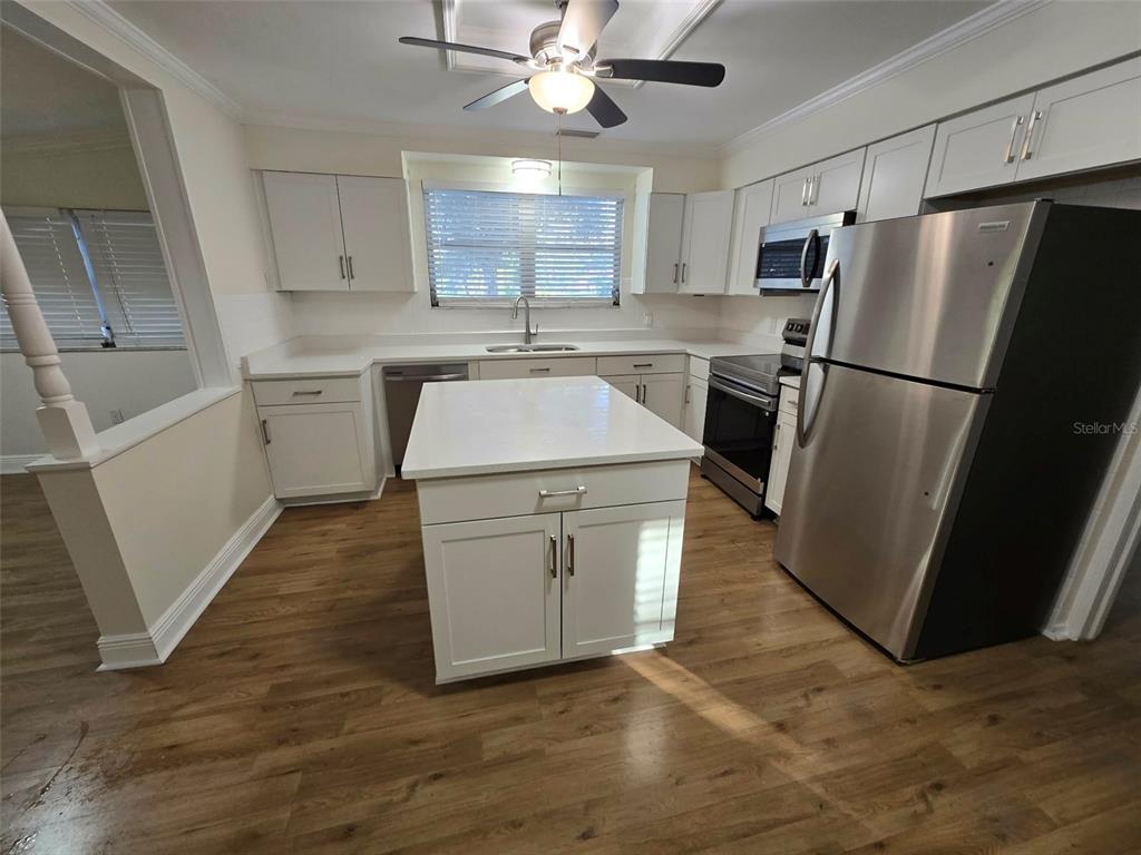 3301 West Woodlawn Avenue Tampa, FL 33607 - Photo 10 of 39 a kitchen with a sink a refrigerator a microwave and cabinets