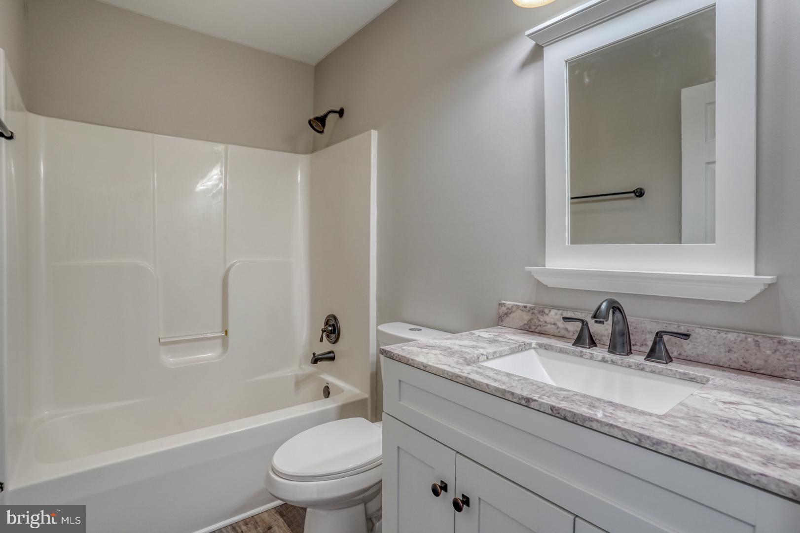 39 High Street Kenton, DE 19955 - Photo 22 of 49 a bathroom with a granite countertop sink a toilet and shower