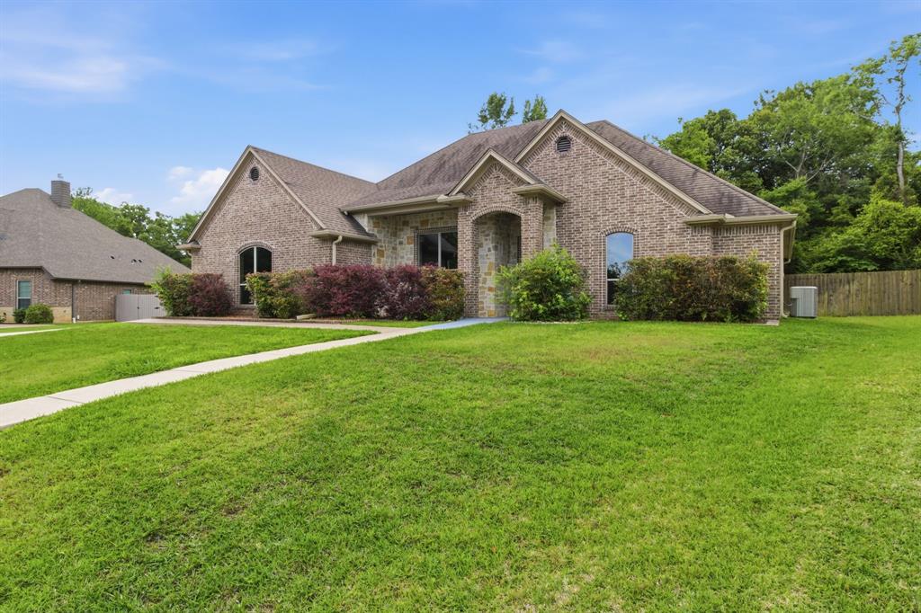 7765 Hickory Spring Lane Tyler, TX 75703 - Photo 4 of 38 Brick and stone exterior featuring an arched entry, multiple gables, and a shingle roof