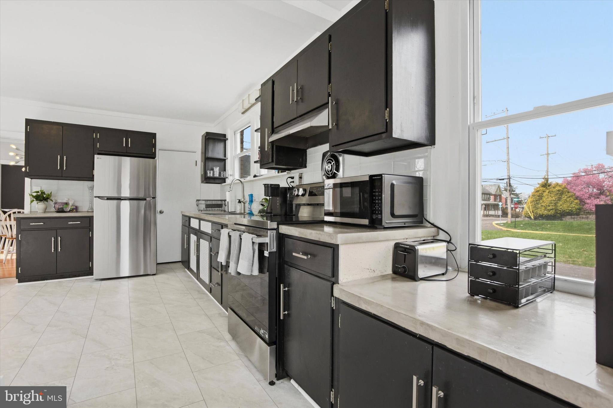 429 Main Street Green Lane, PA 18054 - Photo 7 of 25 a kitchen with stainless steel appliances granite countertop a refrigerator a stove top oven a sink dishwasher and white cabinets with wooden floor
