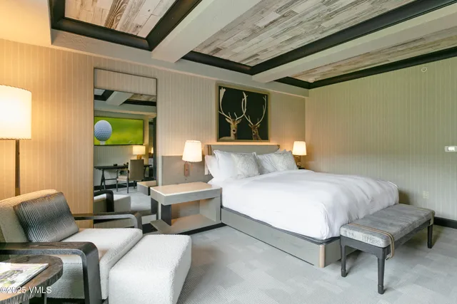 a spacious bedroom with a bed and a chandelier