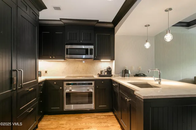 a kitchen with a sink and steel appliances