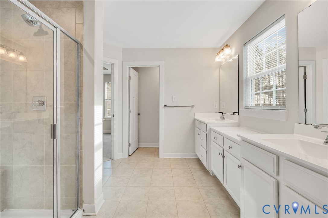 8601 Forge Gate Lane Chesterfield, VA 23832 - Photo 39 of 42 a spacious bathroom with a double vanity sink a mirror and a shower