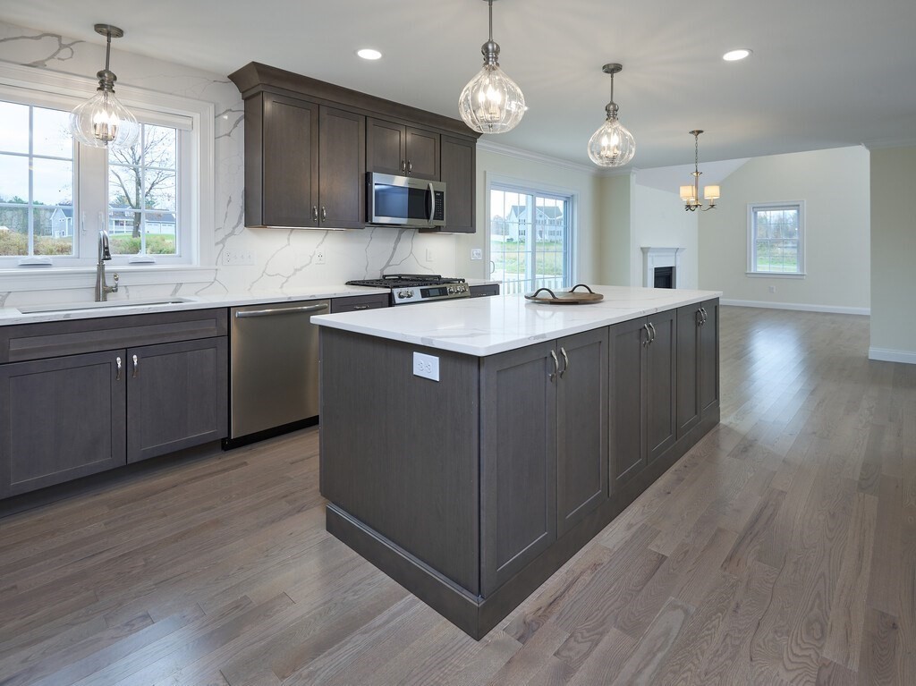 795 Leominster Road Lunenburg, MA 01462 - Photo 2 of 33 a kitchen with kitchen island granite countertop a sink cabinets and wooden floor