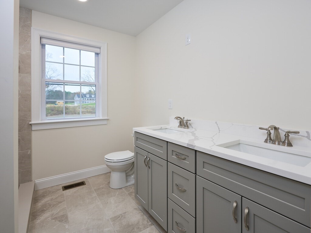 795 Leominster Road Lunenburg, MA 01462 - Photo 23 of 33 a bathroom with a toilet a sink a window and mirror