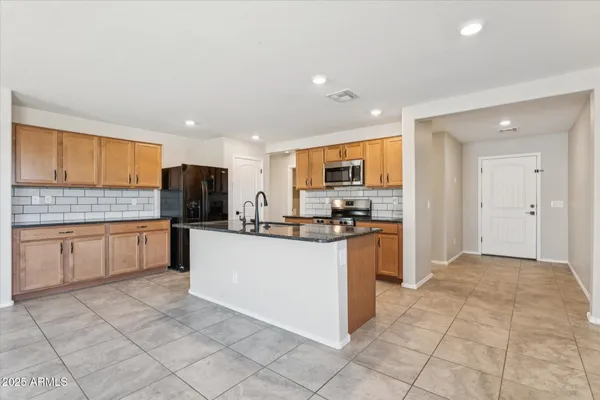 a kitchen with stainless steel appliances a refrigerator sink and cabinets