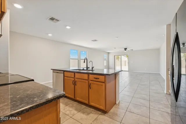 a kitchen with stainless steel appliances granite countertop a sink and a refrigerator