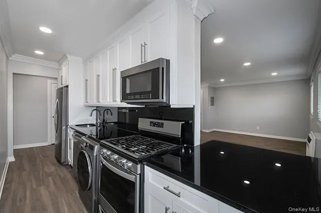 a kitchen with stainless steel appliances granite countertop a stove a refrigerator and a microwave