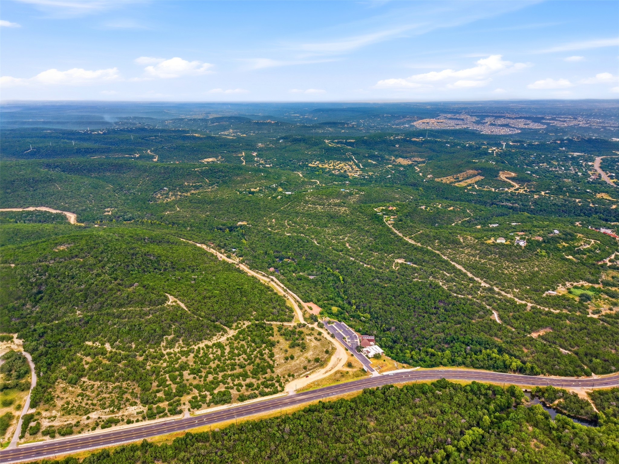 Rolling green hills stretch across the horizon under an expansive blue sky.
