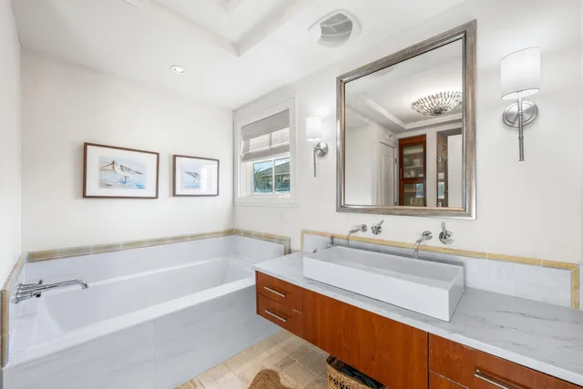 a bathroom with a granite countertop sink a mirror and shower
