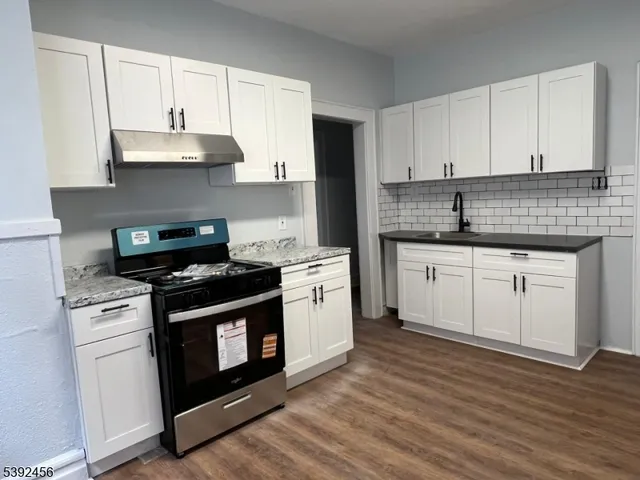 a kitchen with white cabinets and appliances