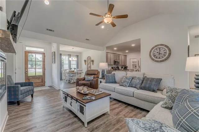 a living room with furniture a clock on wall and a window