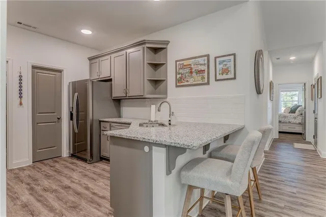 a kitchen with stainless steel appliances granite countertop a refrigerator and a stove top oven