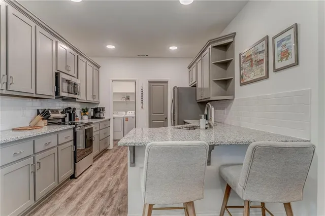 a large kitchen with stainless steel appliances granite countertop a sink and cabinets