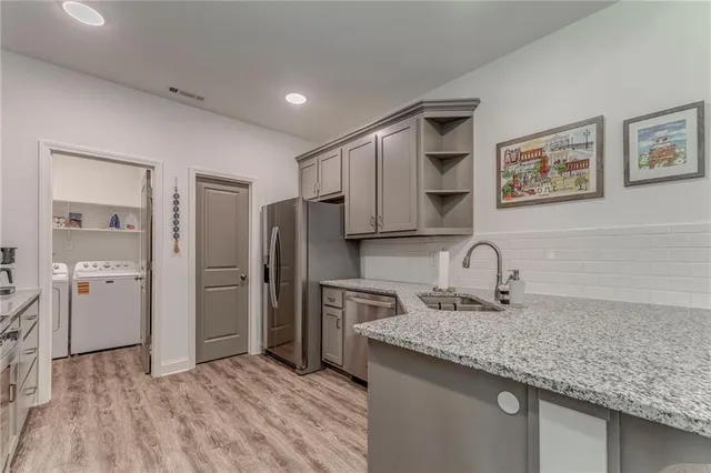 a kitchen with stainless steel appliances granite countertop a sink and refrigerator
