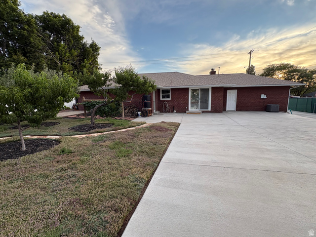 1180 North 400 East Bountiful, UT 84010 - Photo 42 of 50 Brick exterior with a shingle roof, featuring mature trees and a substantial concrete patio