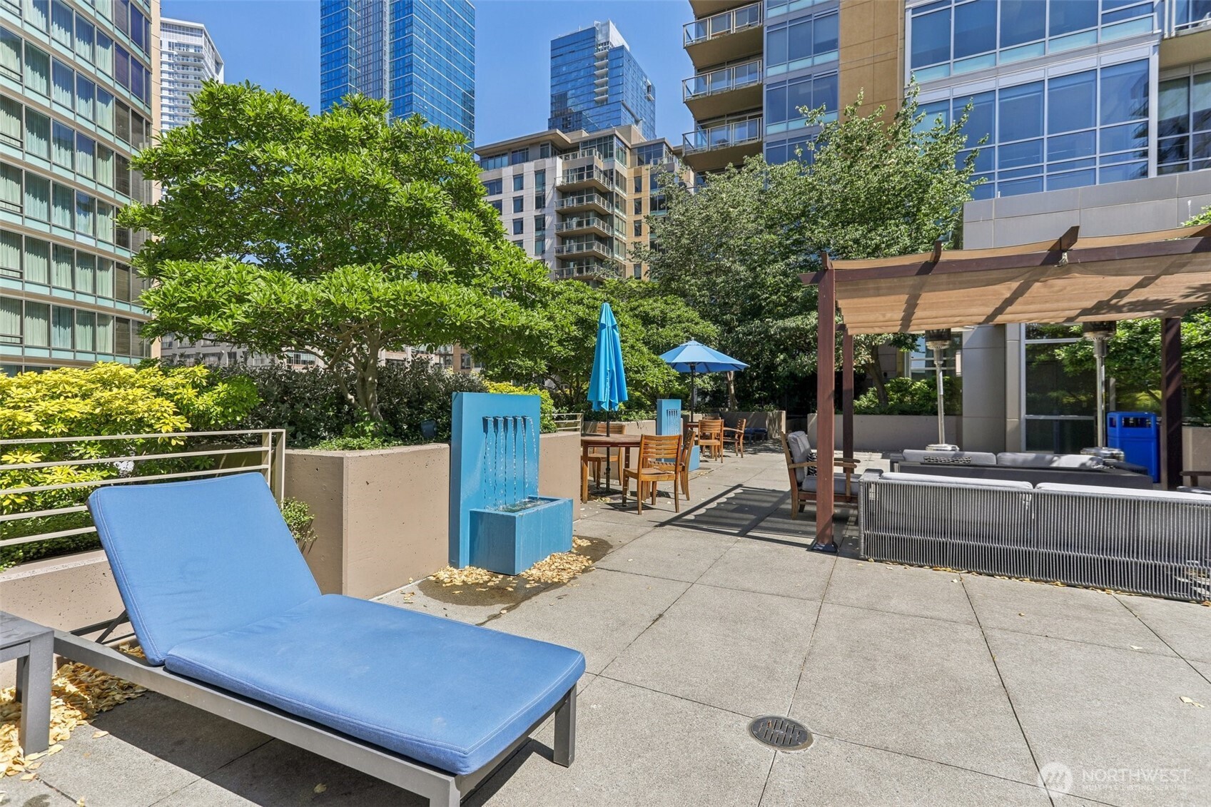 900 Lenora Street, Unit W106 Seattle, WA 98121 - Photo 36 of 40 a view of a patio with a table and chairs under an umbrella with potted plants