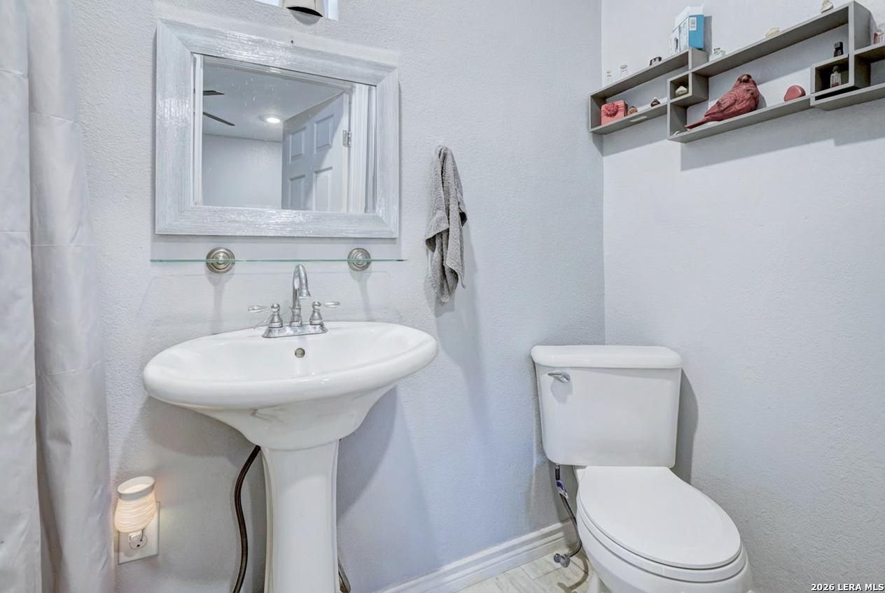 309 South Rolling Oaks Lane San Antonio, TX 78253 - Photo 16 of 43 a white toilet sitting next to a bathroom sink