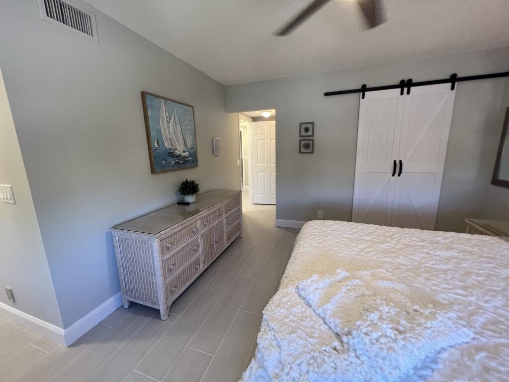 17081 Waterbend Drive, Unit 229 Jupiter, FL 33477 - Photo 15 of 26 a bedroom with a bed and a window
