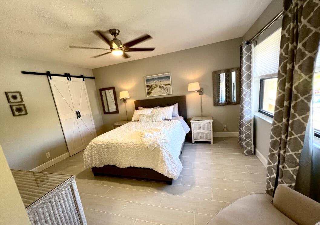 17081 Waterbend Drive, Unit 229 Jupiter, FL 33477 - Photo 18 of 26 a bedroom with a bed and a chandelier