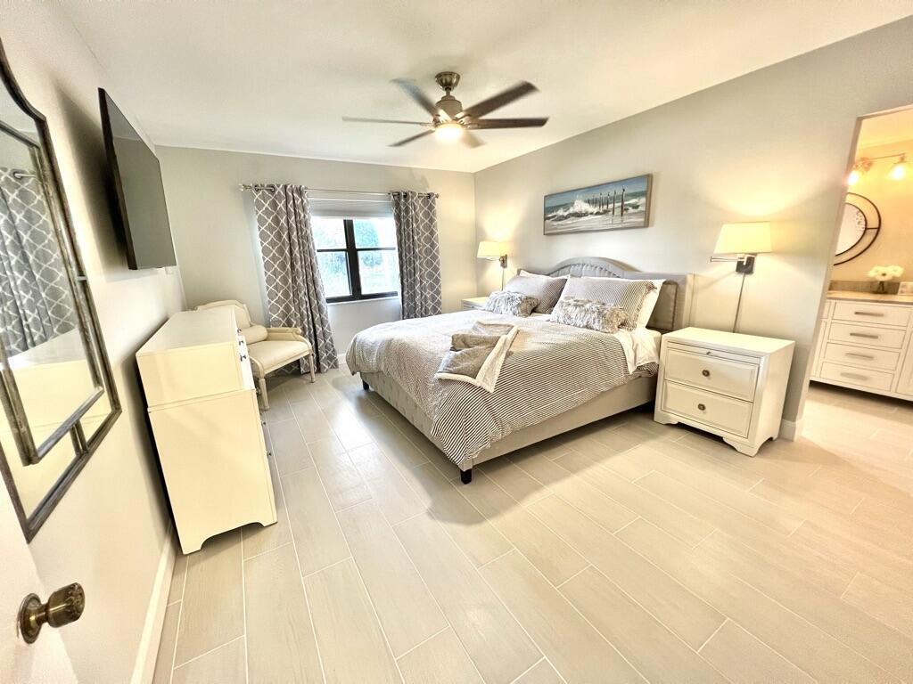 17081 Waterbend Drive, Unit 229 Jupiter, FL 33477 - Photo 23 of 26 a spacious bedroom with a bed couch and window