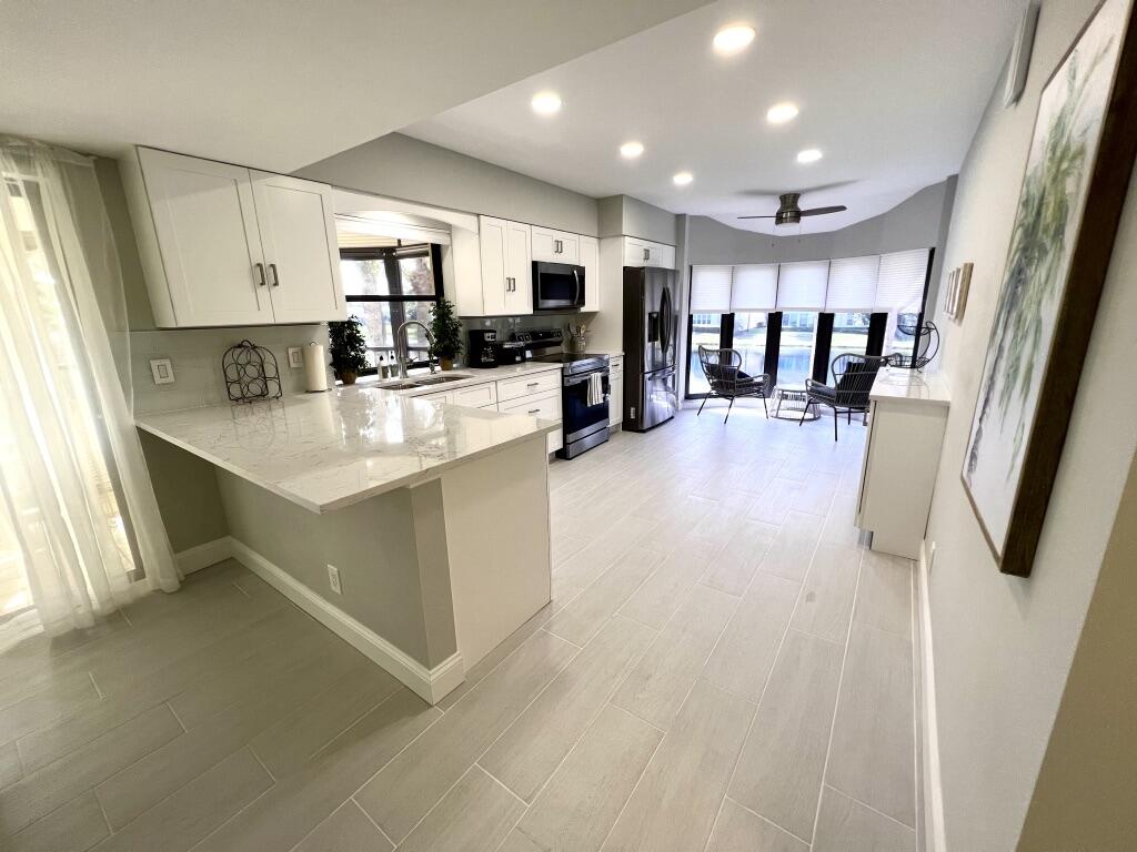 17081 Waterbend Drive, Unit 229 Jupiter, FL 33477 - Photo 3 of 26 a large white kitchen with lots of counter top space a sink and appliances