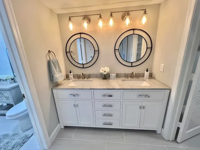 a bathroom with a granite countertop a sink and a mirror