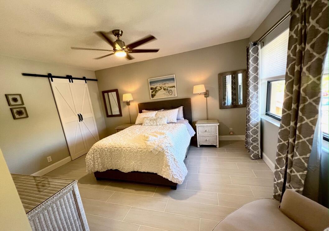 17081 Waterbend Drive, Unit 229 Jupiter, FL 33477 - Photo 7 of 26 a bedroom with a bed and a chandelier