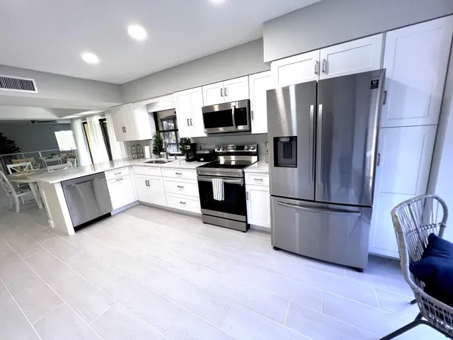 a kitchen with stainless steel appliances a refrigerator sink and microwave