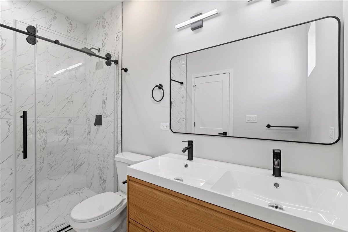 4537 South Evans Avenue, Unit 2 Chicago, IL 60653 - Photo 12 of 12 a bathroom with a white sink a toilet and shower